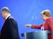 Dort geht's raus - so könnte es Umfragen zufolge für den ukrainischen Präsidenten bald aussehen. Demzufolge würde Herausforderer Selenskyj Poroschenko (links, bei Kanzlerin Merkel in Berlin) in der Stichwahl am Ostersonntag aus dem Amt jagen. (Bild: KEYSTONE/EPA/CLEMENS BILAN)