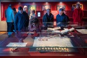 Besucher bestaunen eine mittelalterliche Urkunde im neu eröffneten Ausstellungssaal des St. Galler Stiftsarchivs. (Bild: Urs Bucher)