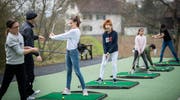 Unter fachkundiger Anleitung durch Ian Gibbons lernen die Kinder auf der Driving Range das Golfen. (Bild: Reto Martin)