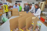 Die Kiwanis-Mitglieder verpacken die letzten Osterpäckli. Heinz Schadegg und Confiseur Stefan Bachmann schauen zu. (Bild: Mario Testa)