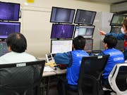 Arbeiter steuern den Roboterarm, der Brennstäbe aus dem Abklingbecken von Reaktor 3 herausholt. (Bild: Kyodo News/AP, Fukushima, 15. April 2019)