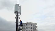 Ein Arbeiter auf einer 5G-Antenne.