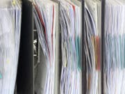 Akten stehen in einem Büro - 67,5 Prozent der Unternehmen klagen über eine hohe oder eher hohe administrative Belastung. (Bild: Keystone/DPA/MAURIZIO GAMBARINI)
