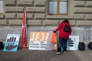 Noch gibt es sie: Eine Aktivistin der Auns ordnet Plakate bei der Übergabe einer Petition mit dem Titel «Stopp UNO-Migrationspakt» an die Bundeskanzlei. (Bild: Alessandro della Valle, Keystone, Bern, 20. November 2018)