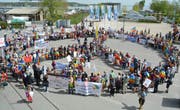 Die Teilnehmer des Friedensweges bilden auf Klein Vendedig ein Peace-Zeichen. (Bild: Judith Schuck)
