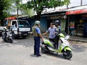 Soldaten überprüfen in Colombo Motorradfahrer. Seit den Anschlägen auf Kirchen und Hotels am Sonntag mit mindestens 359 Toten wurden insgesamt 76 Verdächtige festgenommen. (Bild: KEYSTONE/AP/ERANGA JAYAWARDENA)