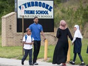 Ein Vater holt seinen Sohn von der Schule im US-Südstaat Georgia ab, nachdem ein Unbekannter zehn Schüler mit Schrotkugeln verletzt hat. (Bild: KEYSTONE/AP Atlanta Journal-Constitution/ALYSSA POINTER)