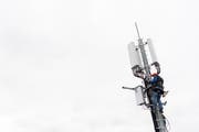 Ein Angesteller arbeitet Anfang Monat an einer 5G-Antenne der Swisscom in Chene-Bougeries (GE). (Bild: Keystone/Martial Trezzini)