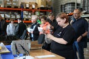 Eine Mitarbeiterin fädelt die Speichen auf.