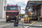 Mittels Seilzug giesst ein Feuerwehrautofahrer Wasser aus einer Spritzkanne in einen Eimer. (Bild: PD)