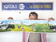 Jacques Froidevaux vom Künstlerkollektiv Plonk & Replonk posiert mit dem Entwurf eines Monumentalgemäldes, das in La Chaux-de-Fonds installiert werden soll. Anlass ist die 2009 erfolgte Aufnahme der Stadt in die Liste der UNESCO-Welterbestätten 2009. (Bild: Keystone/ADRIEN PERRITAZ)
