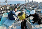 In luftiger Höhe entfernen Handwerker die vergoldete Kugel von der Kirchturmspitze. (Bild: Fritz Heinze)