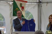 Regierungsrat Walter Schönholzer präsentiert am Jubiläumsfest das Trikot des Armbrustschützenvereins Buhwil-Neukirch. (Bild: Christoph Heer)