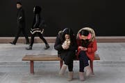 Chinesinnen konsultieren ihr Smartphone - für KP-Mitglieder nun aufgrund der neuen App auch ein politischer Akt. (Bild: Kevin Frayer/Getty; Peking, 19. Januar 2016)