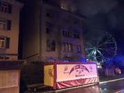 Nächtlicher Brand an der Sonnenstrasse in St. Gallen: Wegen des dichten Rauchs aus der brennenden Wohnung im ersten Stock flüchteten mehrere Bewohner unter das Dach des Hauses. (Bild: Kantonspolizei St. Gallen)