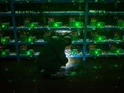Ein Bitcoin-Schürfer nimmt die Mining-Maschinen in einer chinesischen Provinz in Augenschein. Die chinesische Regierung will das Schürfen von Digitalwährungen unterbinden. (Bild: KEYSTONE/EPA/LIU XINGZHE/CHINAFILE)