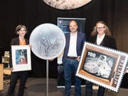 50 Jahre Mondlandung: Nicola von Greyerz von der Uni Bern zeigt das Jubiläumssignet der Hochschule, Christoph Tanner von Swissmint die Sondermünze und Bernhard Kallen von der Post die Sondermarke. (Bild: zvg / Universität Bern, Bild: Ramon Lehmann)