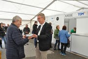 OK-Präsident Peter Kroll (rechts) überreicht dem ersten Besucher ein Geschenk. (Bild: Sabine Camedda)
