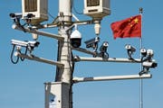 Chinesische Flagge hinter Überwachungstechnik: Peking exportiert fleissig Überwachungssysteme. Bild: Andy Wong/AP (Peking, 15. März 2019)