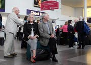 Britische Fluggäste warten beim Check-In auf die Weiterreise. (Scott Heppell/AP)