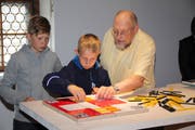 Spielerfinder Urs Wüthrich beobachtet, ob seine beiden Grosskinder, Micha (links) und Luzian Wüthrich, das Spiel richtig demonstrieren. (Bild: Paul Gwerder, Bürglen, 11. Mai 2019)