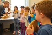 Hansjörg Rechsteiner zeigt den Kindern an der Musikschule, wie man Panflöte spielt. (Bild: Monika Wick)