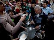 Essensausgabe durch eine Hilfsorganisation in Gaza Stadt zum Fastenbrechen während des Ramadan. (Bild: KEYSTONE/AP/HATEM MOUSSA)