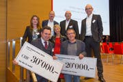 Raphael Frei (links) und Markus Kopf halten die Preischecks; dahinter der Stiftungsrat der Carl-Stürm-Stiftung. (Bild: Christof Sonderegger)