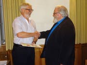 Ernst Engeler, der neue Waldpräsident, überreicht seinem Vorgänger Walter Bollier ein Geschenk. (Bild: Erwin Schönenberger)