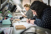 Zwei Frauen sitzen im Fachbereich Elektro des Werk 57 an praktischen Übungen im Löten. (Bild: Reto Martin)