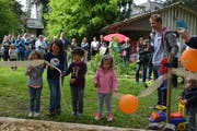 Unter Anleitung von Reto Scherrer eröffnen die Kinder den neuen Schaukelspielplatz im Familienzentrum. (Bild: Monika Wick)