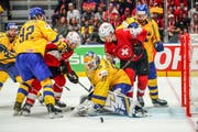 Die Schweizer Tristan Scherwey (links) und Gaetan Haas (Mitte, im roten Dress) kämpfen gegen die Schweden vor deren Tor. (Bild: Andy Müller/Freshfocus, Bratislava, 18. Mai 2019)