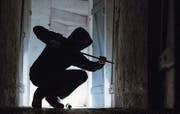 Im Bild (gestellte Szene) hebelt ein Einbrecher eine Türe auf. (Bild: Keystone / Silas Stein)
