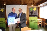 Der neue Präsident der Arbeitgebervereinigung der Region Toggenburg (ART), Samuel Schiess (links) überreicht seinem Vorgänger Philippe Schiess ein Geschenk zum Dank für den Einsatz für die ART. (Bild: Martin Knoepfel)
