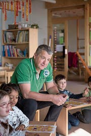 Lotto im Kindergarten: Toni Steinmann hilft Buben und Mädchen beim Zahlensuchen. (Bild: Adriana Ortiz Cardozo)
