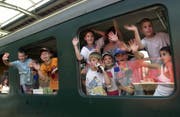 Kinder winken aus einem Zug. (Bild: Keystone)