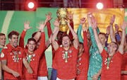 Doppeltorschütze Robert Lewandowski hebt den Cup-Pokal, seine Teamkollegen feiern mit. (Bild: Jan Woitas/Keystone (Berlin, 25. Mai 2019))