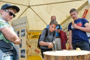Die Buben versuchen, einen Nagel mit möglichst wenigen Hammerschlägen in den Baumstrunk zu hauen. (Bild: Donato Caspari)