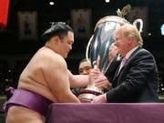 US-Präsident Trump überreicht dem Sieger des Sumo-Ringer-Turniers den eigens dafür geschaffenen «President's Cup». (Bild: KEYSTONE/EPA JIJI PRESS)