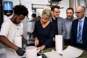 Solomon Aklilu, Teilnehmer des Pilotprogramms Integrationsvorlehre, wird von Bundesrätin Karin Keller-Sutter bei der Arbeit beobachtet. (Bild: Keystone, Anthony Anex)