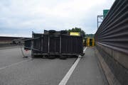 Der umgekippte Anhänger und dahinter das ebenfalls auf der Seite liegende Zugfahrzeug am Montagabend auf der St.Galler Stadtautobahn. (Bild: Kantonspolizei St.Gallen - 28. Mai 2019)