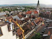 Arbeiter installieren auf dem Turm der evangelischen Stadtkirche ein Storchenrad. (Bild: PD/Thomas Moos (Toggenburger + Co AG))
