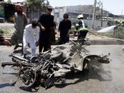 Menschen in Kabul sehen sich das Wrack des Autobombers an. (Bild: KEYSTONE/EPA/JAWAD JALALI)