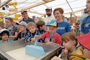 Der vierjährige Maurin Erni versucht sich im Handwerk des Käsers. Im Hintergrund (von links): Priska Niederberger, Schaukäser Armin Röllin und Lydia Barmettler. (Bild: Richard Greuter, Buochs, 31. Mai 2019)