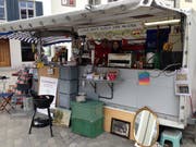 Immer am ersten und am letzten Samstag im Monat, abwechselnd auf dem Gallusplatz und im St.-Mangen-Quartier, findet in der St.Galler Altstadt der Flohmarkt oder Flöhmi statt. Diesen Samstag wurde er am frühen Nachmittag gewaltig verregnet und verhagelt. Vorher aber war er in Betrieb. Unter den Ständen stach einer vor allem ins Auge, nämlich eine Kombination aus Flohmarktstand und Flohmarktbeizli mit Getränken, Snacks, Würsten vom Grill und Süssigkeiten. (Bild: Reto Voneschen)