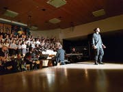 Gian-Luca Bonderer aus Buchs (vorne) und der Cantichor Sargans sorgen für gute Stimmung in der ausverkauften Aula der Kantonsschule Sargans. (Bild: Nadine Schwizer)