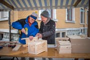 Mit Mütze und Schal: Zwei Männer schrauben am Maimarkt einen Nistkasten zusammen. (Bild: Benjamin Manser)