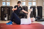 Im Therapiezentrum Kronenhof in Berlingen trainiert Physiotherapeut Manuel Kotzur mit Wolfgang Lichey. Auf dem Bild übt Lichey, wie man nach einem Sturz aus eigener Kraft wieder aufstehen kann. (Bild: Reto Martin)