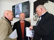 Autor Alfons Bieger (rechts im Bild) mit dem Buch «Das Schlössliareal» unterhält sich mit Museumsbesuchern. (Bild: Yvonne Aldrovandi-Schläpfer)