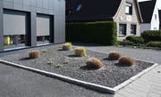 Pflanzen ragen aus einem Vorgarten mit grauen und schwarzen Kieselsteinen. Bremen sagt jetzt den Schottergärten den Kampf an und will grosse Steinflächen verbieten. (Bild: Keystone)